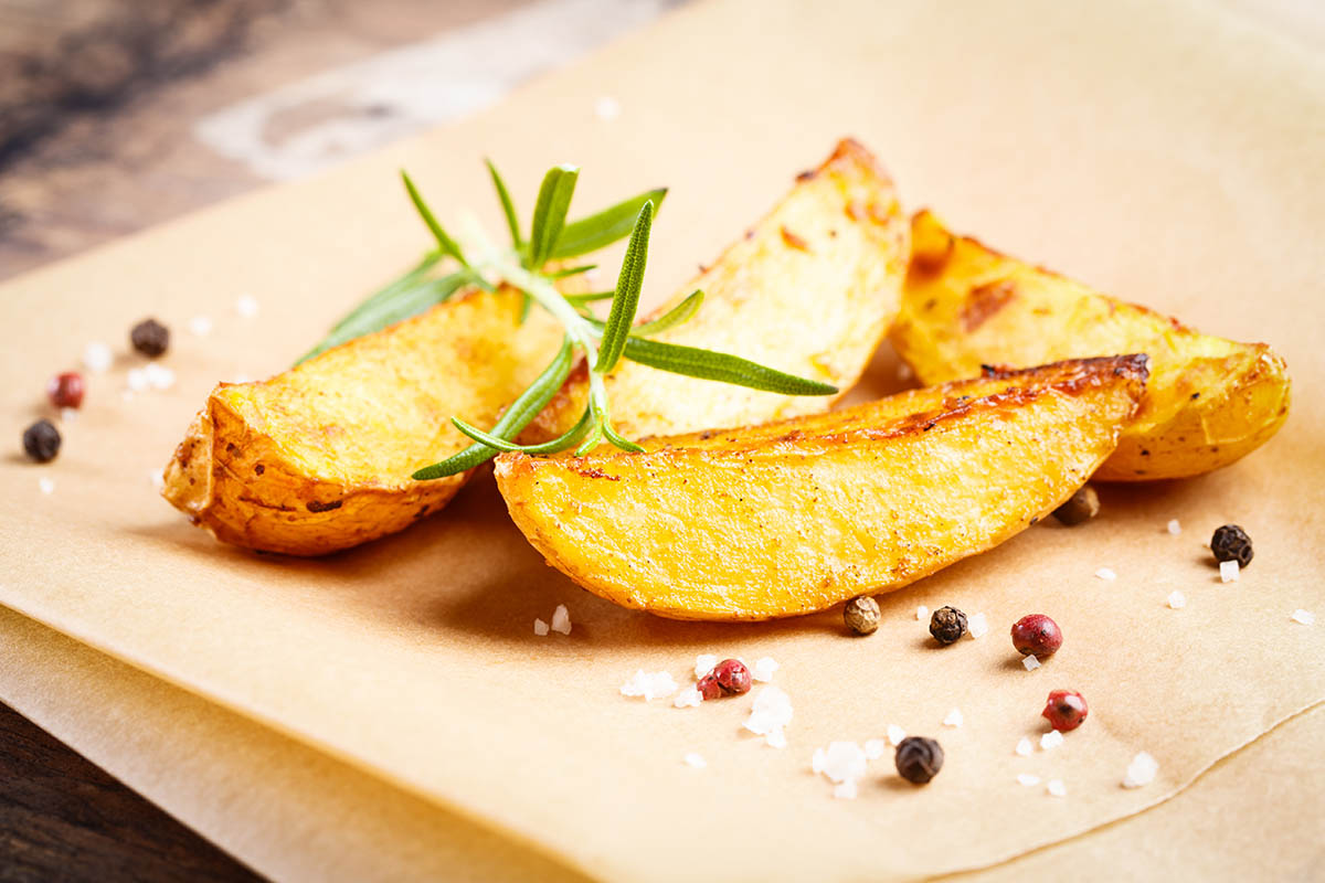 Stockfoto - Knusprig gebratene Kartoffelspalten mit Rosmarin