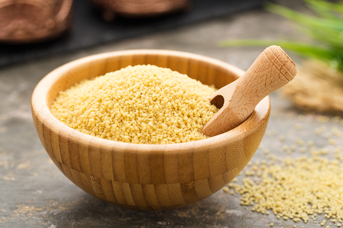 Stockfoto - Ungekochter Couscous in einer Holzschüssel