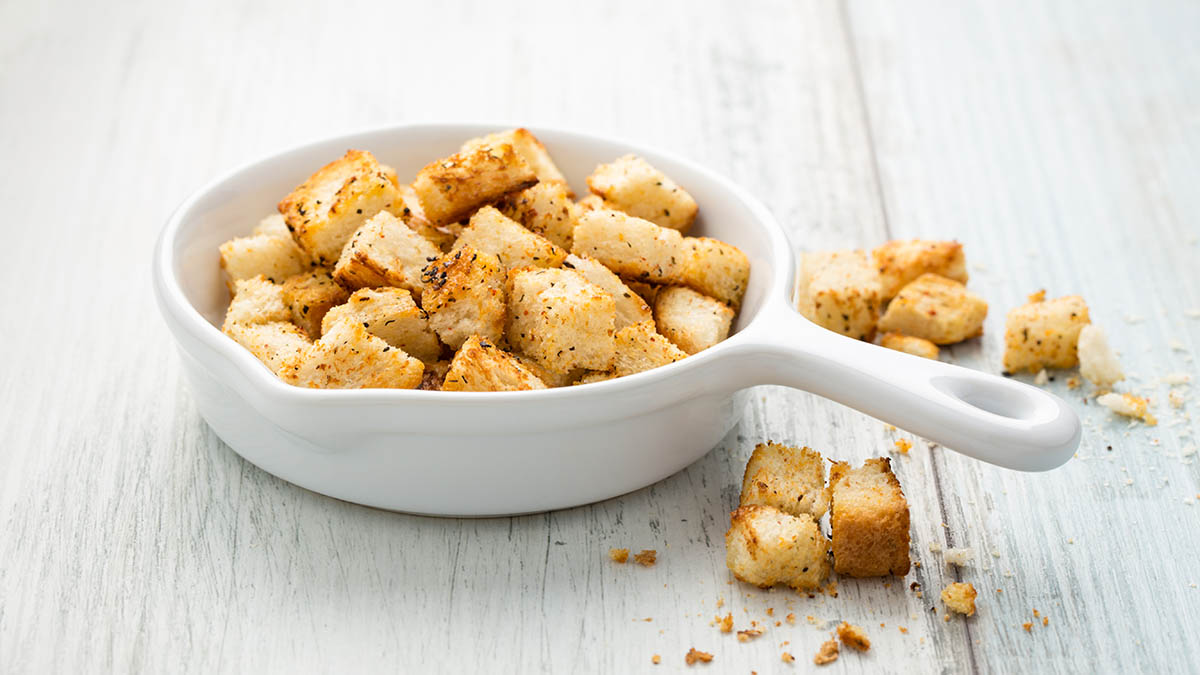 Stockfoto - Hausgemachte Kräutercroûtons in einem Pfännchen.
