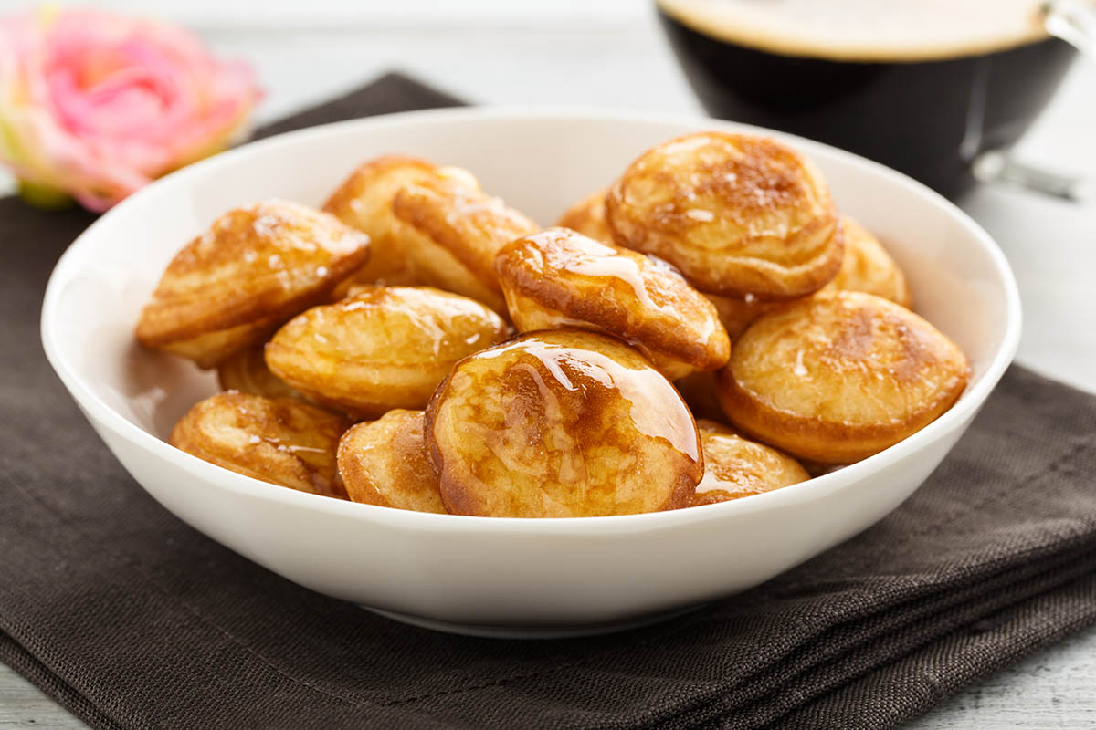 Stockfoto - Poffertjes - Minipfannkuchen mit Puderzucker und Honig