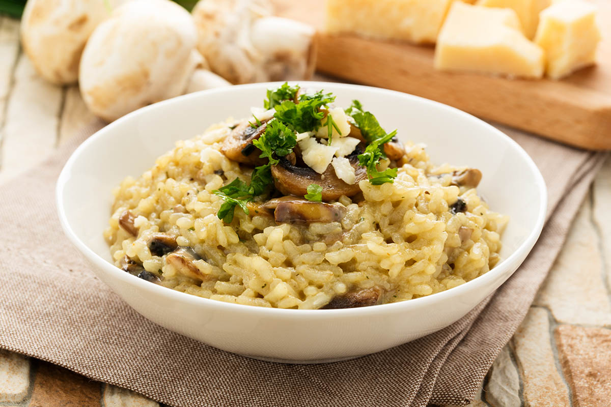 Stockfoto - Traditionelles Risotto mit Champignons, frischen Kräutern und Parmesan