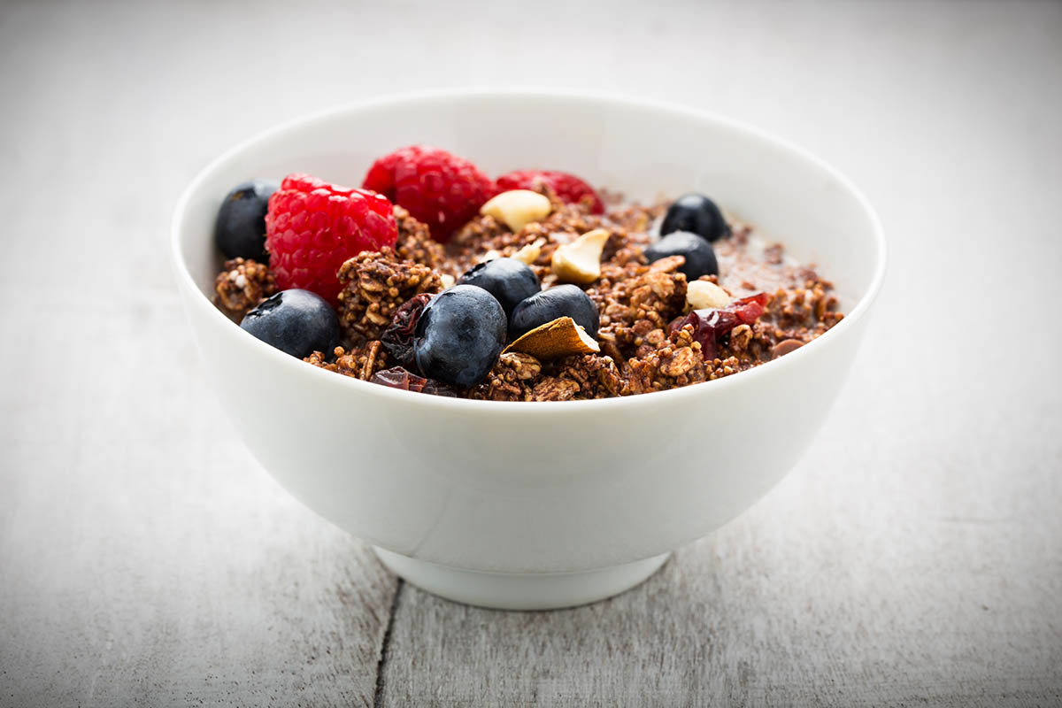 Stockfoto - Schokomüsli mit frischen Beeren, Nüssen und getrockneten Früchten